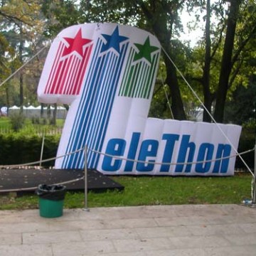 Large Telethon sign with star designs in a park setting.