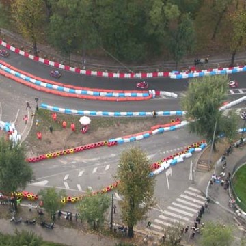 Aerial view of a winding go-kart track with racers and colorful barriers.