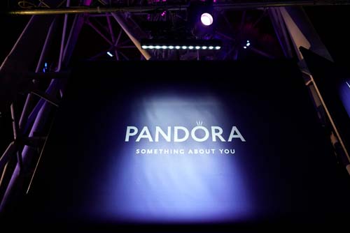 Dark stage with illuminated 'PANDORA' sign and 'Something About You' slogan.