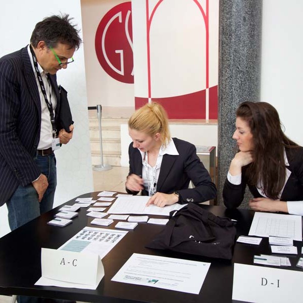 People at a registration table with name tags and paperwork.