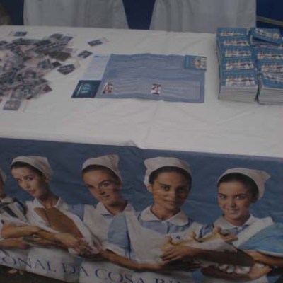 Table with brochures and banner of smiling women in uniforms holding dairy products.
